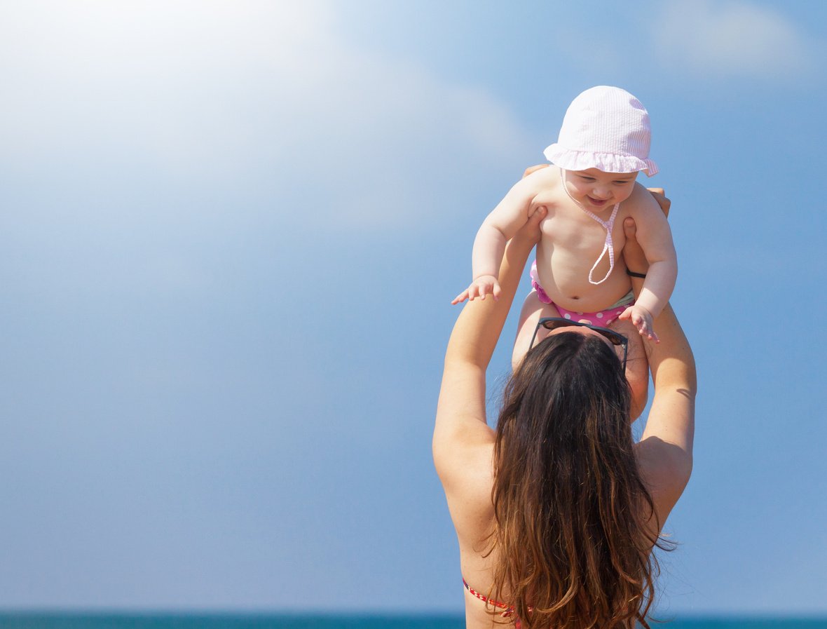 Mom Carrying Baby Girl on the Beach